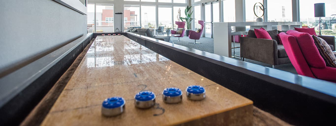 Shuffle board table with 4 blue pucks.