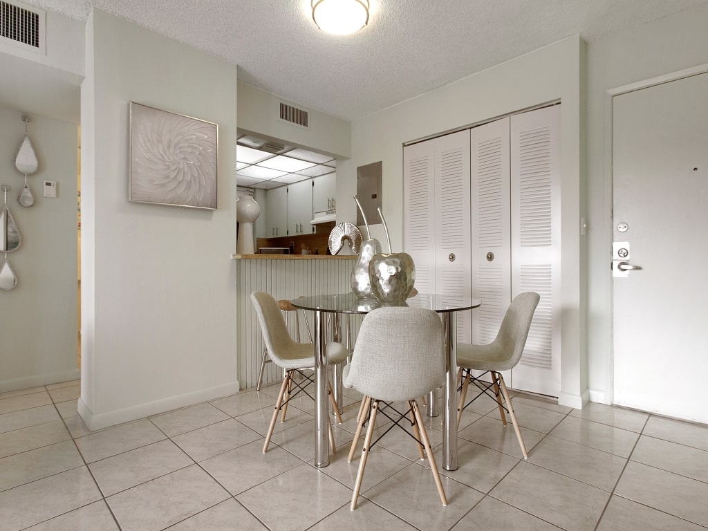 Round dining table with four beige chairs.