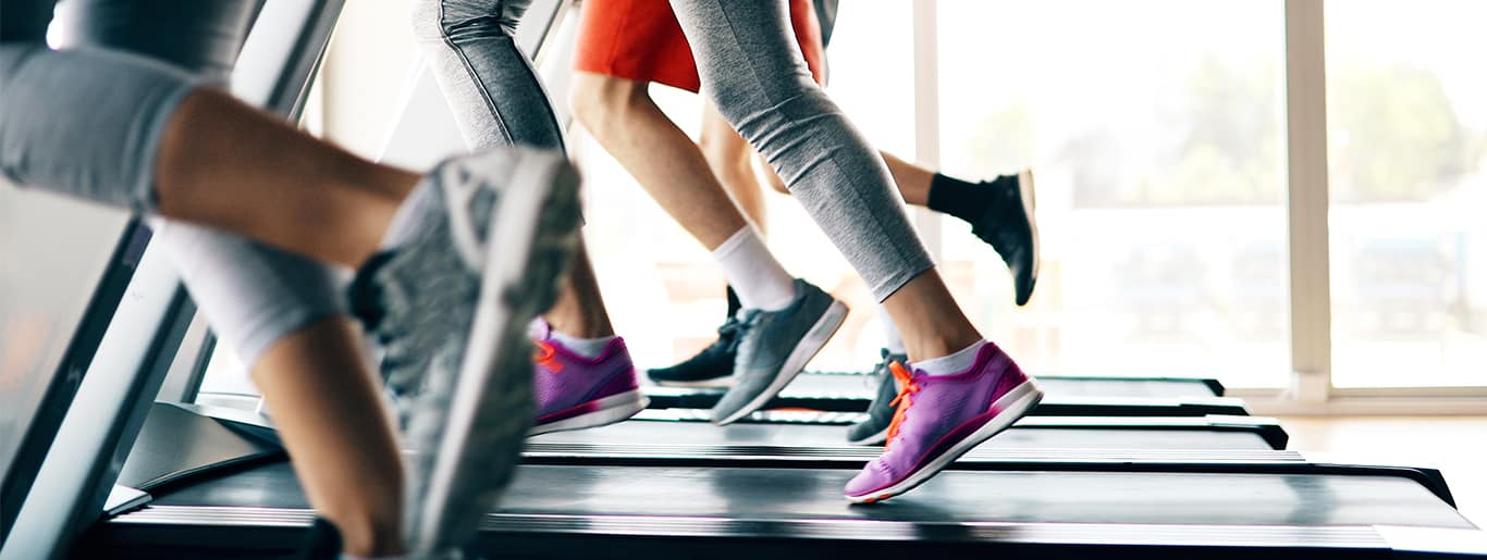 Group of people running on treadmill.