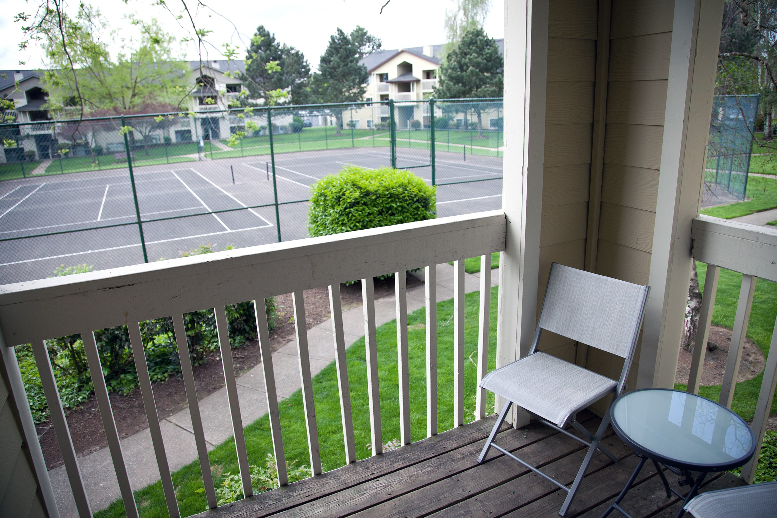 Apartment balcony with table and chair.