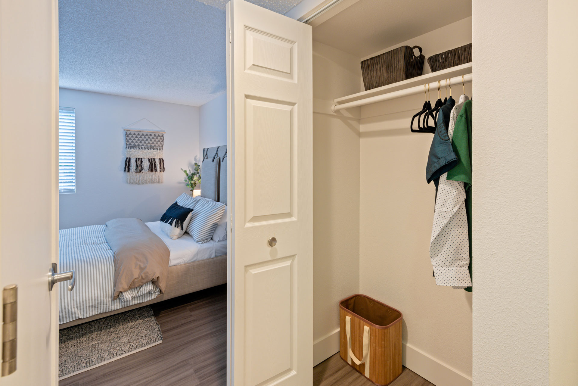 Small closet with blue shirt hanging, open to bedroom.
